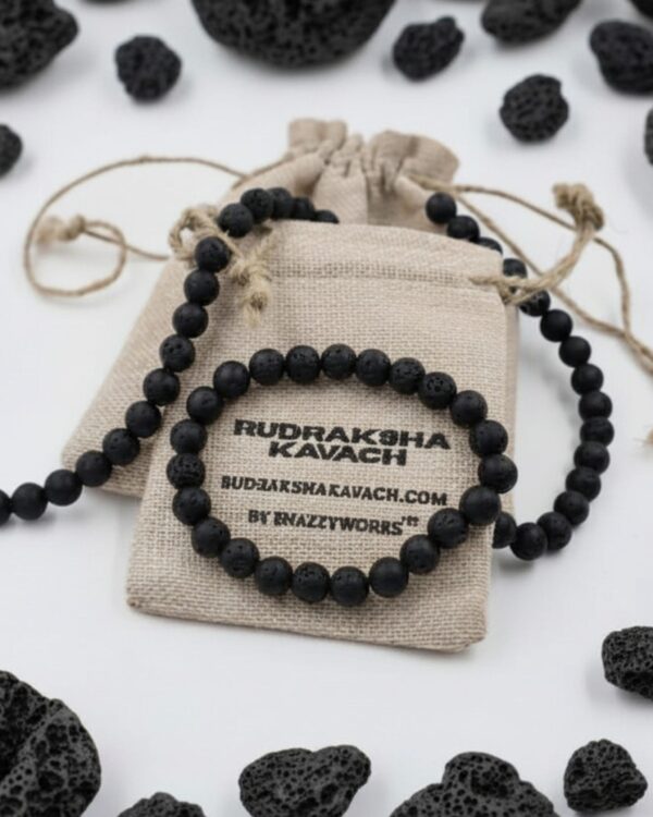 Home A Matte Black, Porous Lava Stone Bracelet Sitting On Top Of A Rustic Linen Pouch. The Pouch Has Printed Text That Reads &Quot;Rudraksha Kavach&Quot; And &Quot;By Snazzyworks&Quot;. Scattered Around The Product On A Clean White Background Are Several Loose, Raw Pieces Of Black Lava Rock.